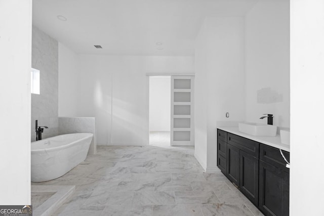 bathroom with a washtub and vanity