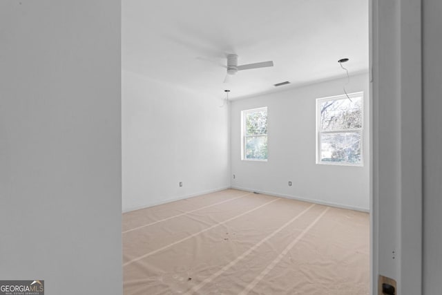 carpeted spare room featuring ceiling fan