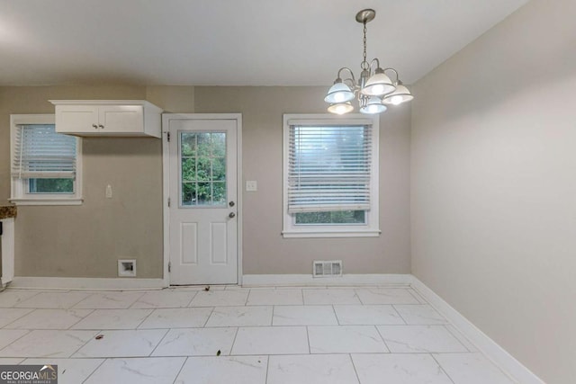 unfurnished dining area featuring a notable chandelier