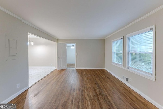 empty room featuring ceiling fan, dark hardwood / wood-style floors, ornamental molding, and electric panel