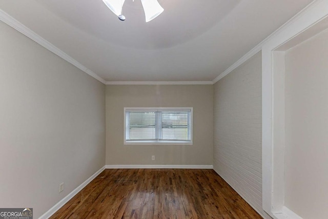 spare room with brick wall, dark hardwood / wood-style flooring, and crown molding