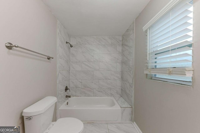 bathroom featuring toilet and tiled shower / bath combo