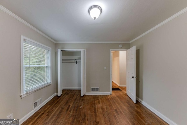 unfurnished bedroom with a closet, dark hardwood / wood-style floors, and ornamental molding