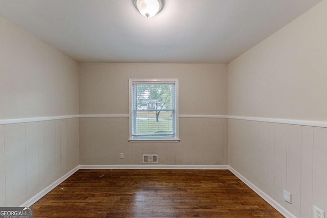 empty room with wood walls and dark hardwood / wood-style floors