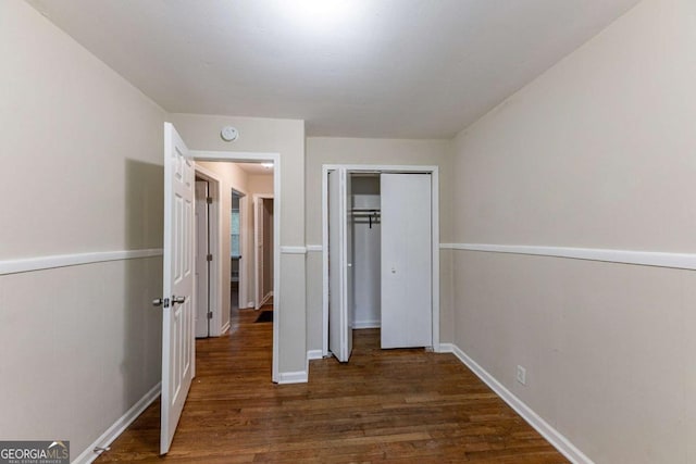 unfurnished bedroom featuring a closet and dark hardwood / wood-style floors