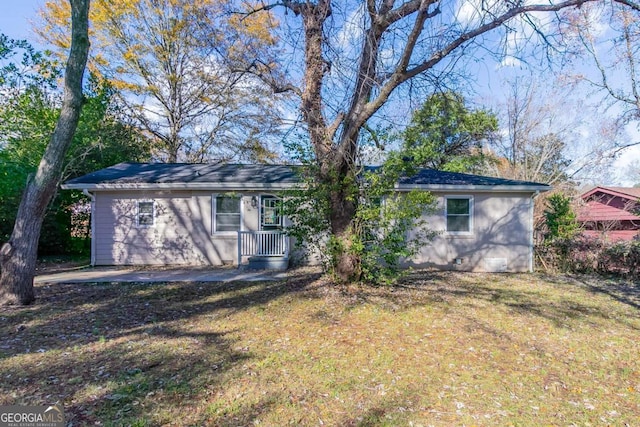 rear view of house featuring a lawn