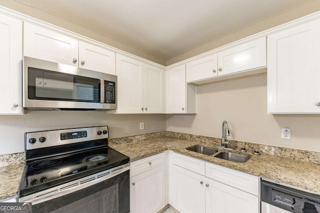 kitchen featuring light stone countertops, appliances with stainless steel finishes, white cabinetry, and sink