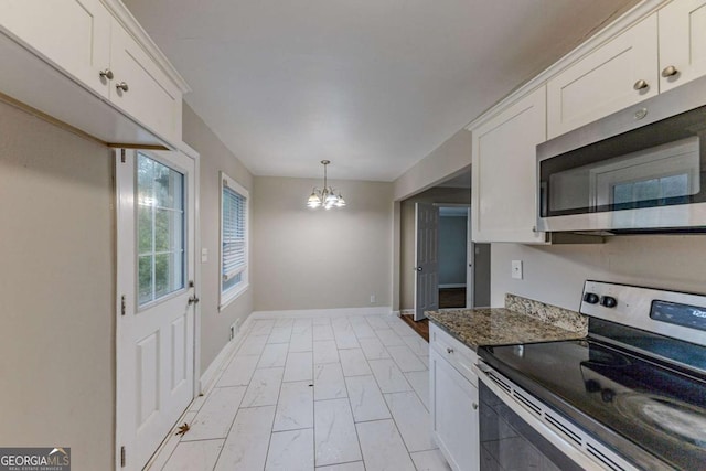 kitchen with stainless steel appliances, a notable chandelier, dark stone countertops, hanging light fixtures, and white cabinets