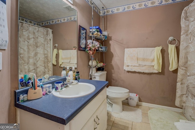 bathroom with toilet, vanity, tile patterned floors, and a textured ceiling