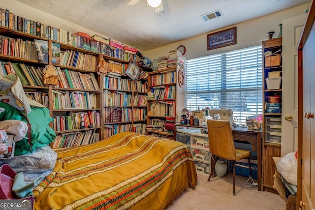 bedroom with ceiling fan, a textured ceiling, and light carpet