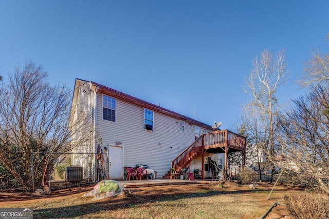 rear view of house featuring a deck and a lawn