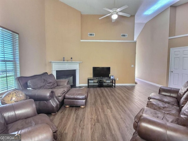 living room featuring ceiling fan, wood-type flooring, and high vaulted ceiling