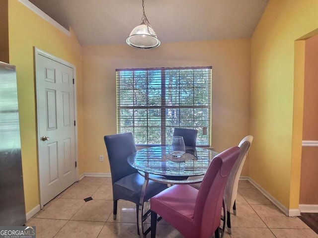 dining space with light tile patterned floors and lofted ceiling