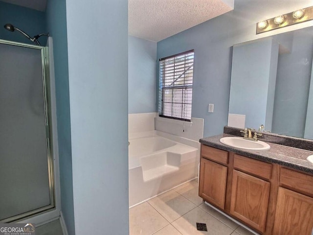 bathroom featuring a textured ceiling, tile patterned flooring, shower with separate bathtub, and vanity