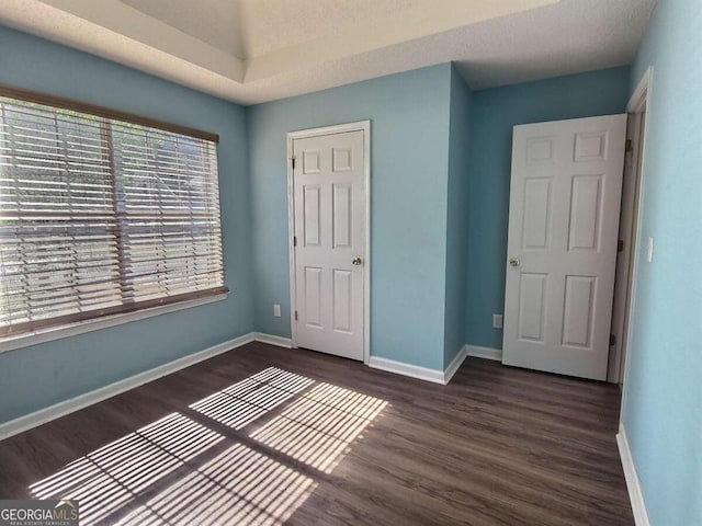 unfurnished bedroom featuring a closet and dark hardwood / wood-style floors