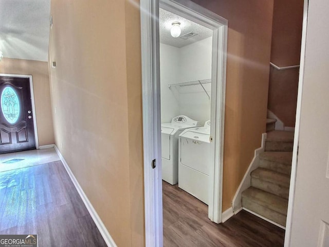 interior space featuring washing machine and dryer, a textured ceiling, and hardwood / wood-style floors