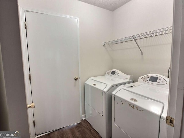 laundry room with a textured ceiling, dark wood-type flooring, and washing machine and clothes dryer