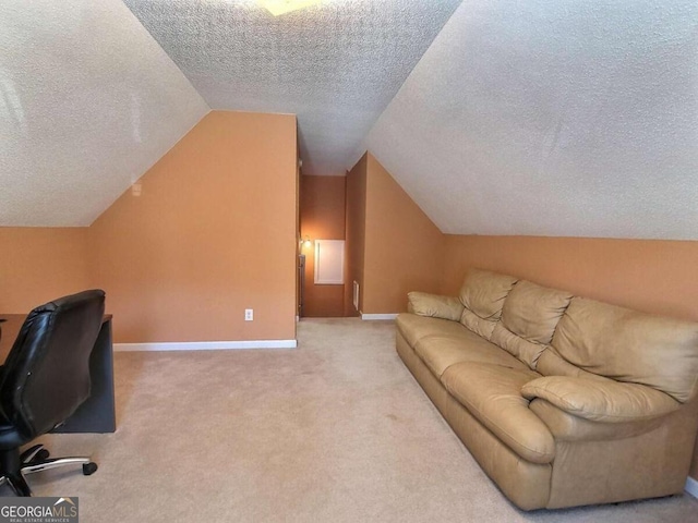 home office featuring a textured ceiling, light carpet, and lofted ceiling