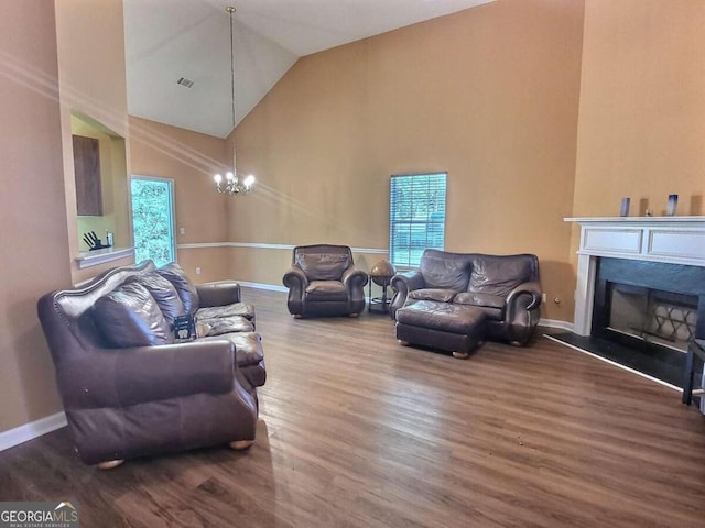 living room featuring wood-type flooring, lofted ceiling, and a chandelier