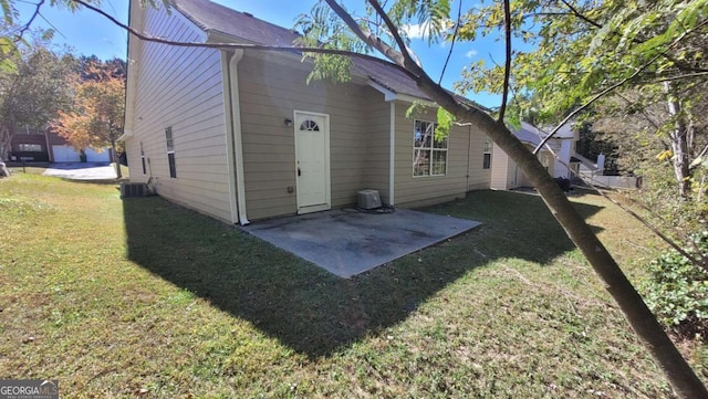 rear view of property with cooling unit, a patio, and a yard