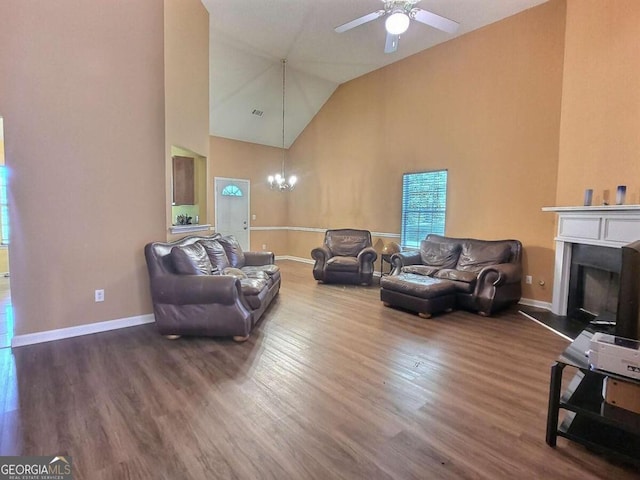 living room featuring lofted ceiling, ceiling fan with notable chandelier, and hardwood / wood-style floors