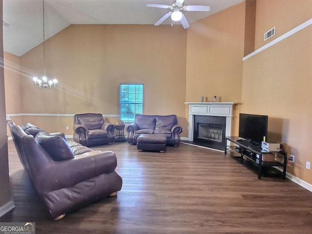 living room featuring ceiling fan with notable chandelier, dark hardwood / wood-style floors, and high vaulted ceiling