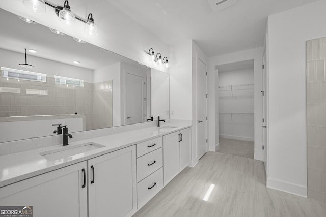 bathroom featuring walk in shower, double vanity, and a spacious closet