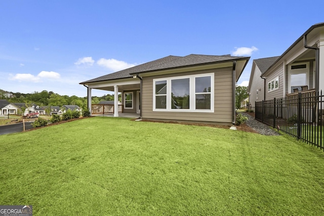 rear view of house with a patio area and roof with shingles