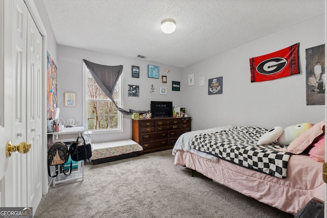 bedroom with carpet, a closet, and a textured ceiling