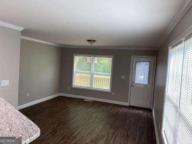 entrance foyer with dark hardwood / wood-style flooring and ornamental molding