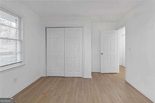 unfurnished bedroom featuring a closet and light wood-type flooring