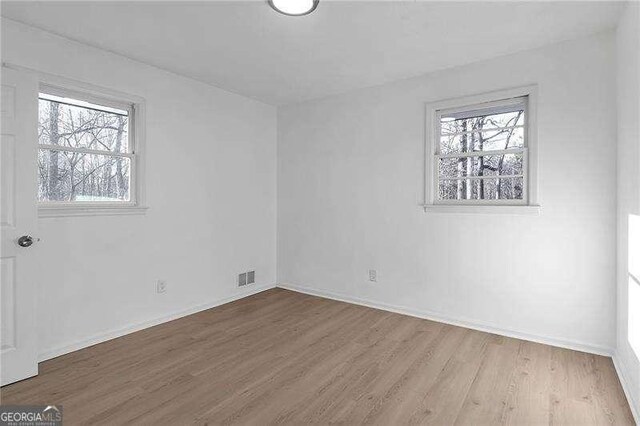 unfurnished room featuring hardwood / wood-style flooring and a wealth of natural light