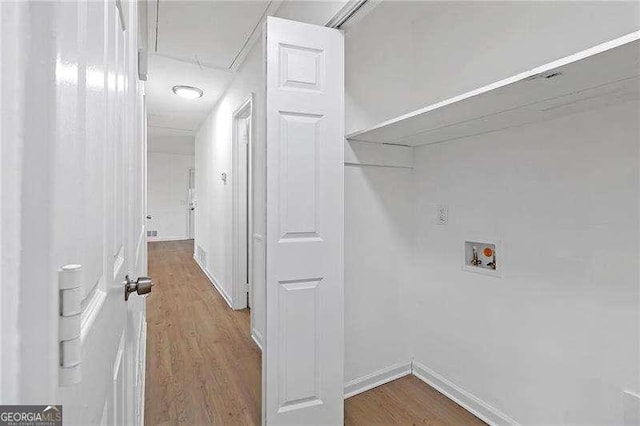 laundry room with hardwood / wood-style flooring and hookup for a washing machine