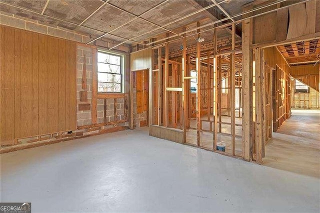 miscellaneous room featuring wood walls and concrete flooring