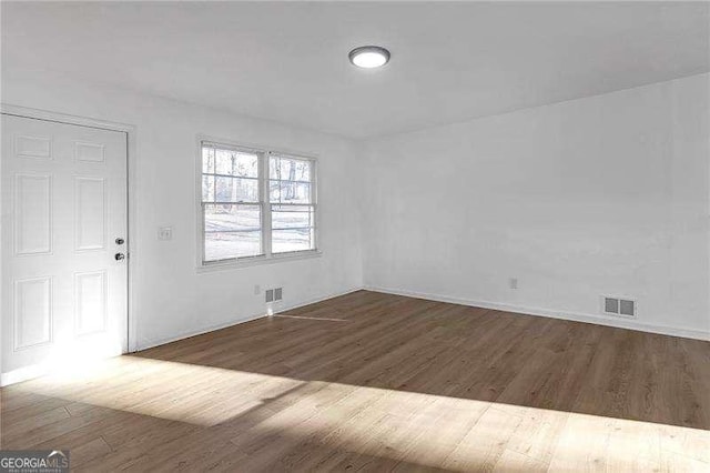 spare room with dark hardwood / wood-style flooring