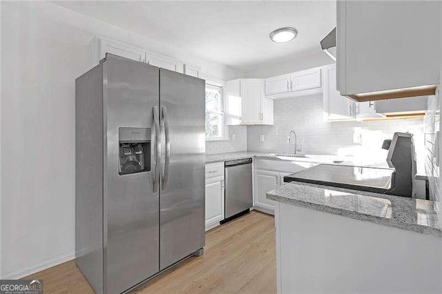 kitchen featuring light hardwood / wood-style floors, stainless steel appliances, light stone countertops, white cabinets, and sink