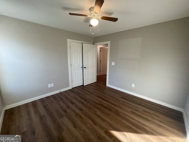 unfurnished bedroom with ceiling fan, a closet, and dark hardwood / wood-style floors