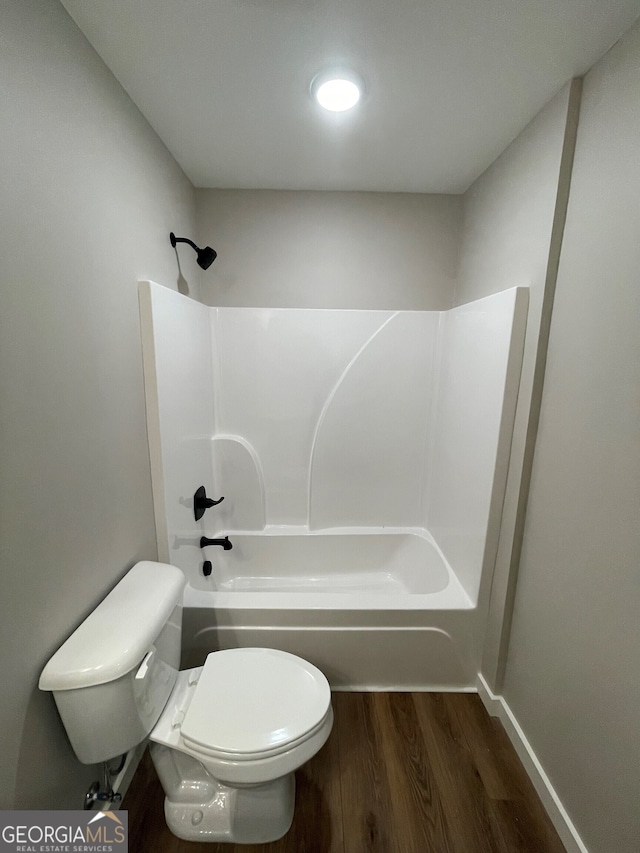 bathroom featuring toilet, wood-type flooring, and shower / bathing tub combination