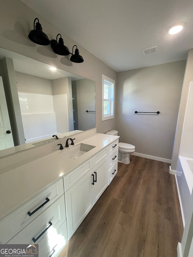 bathroom featuring toilet, hardwood / wood-style floors, and vanity