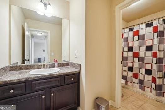 bathroom featuring vanity, tile patterned floors, and toilet