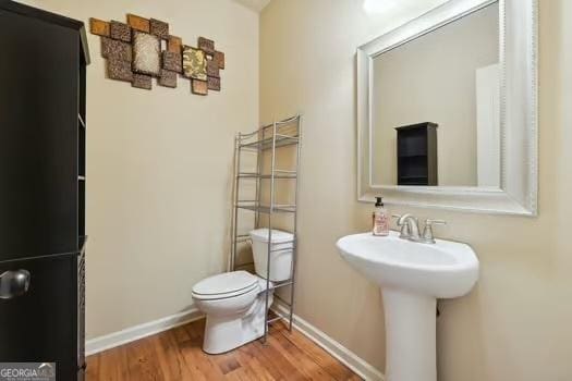 bathroom featuring sink, wood-type flooring, and toilet