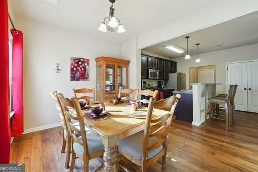 dining room featuring an inviting chandelier and dark wood-type flooring