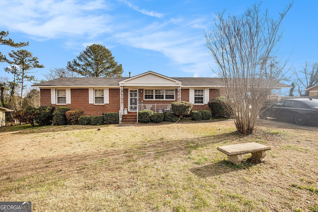 ranch-style home featuring a front yard and covered porch