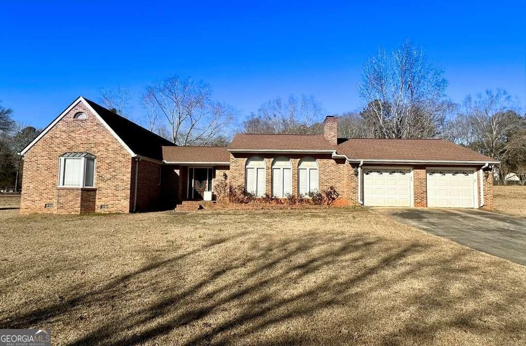 ranch-style house with a front yard and a garage