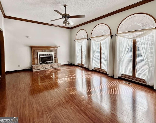 unfurnished living room with a textured ceiling, ceiling fan, a fireplace, and wood-type flooring