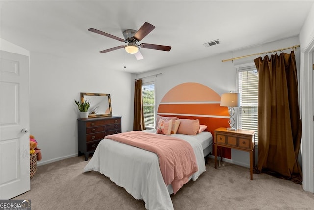 carpeted bedroom with multiple windows and ceiling fan