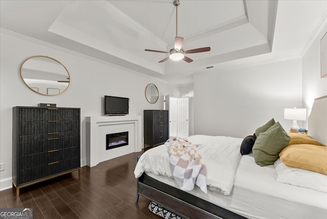 bedroom with crown molding, a tray ceiling, and ceiling fan