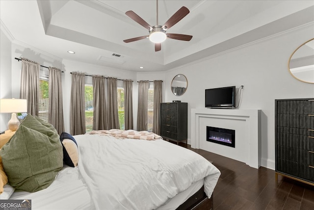 bedroom with dark hardwood / wood-style flooring, ornamental molding, a raised ceiling, and ceiling fan