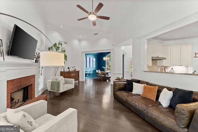 living room featuring ceiling fan, a fireplace, dark hardwood / wood-style flooring, and high vaulted ceiling