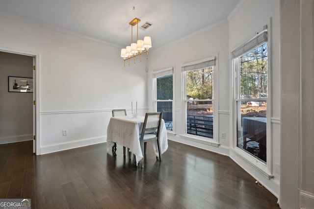 dining space featuring crown molding, dark wood-type flooring, and a notable chandelier